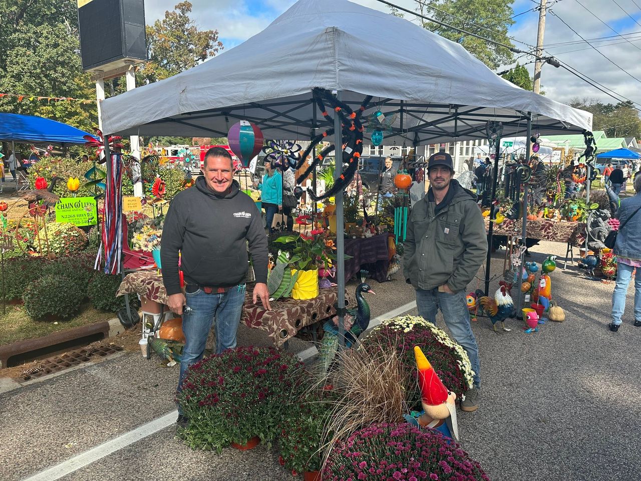 Chain O' Lakes Nursery booth with mums and fall garden art