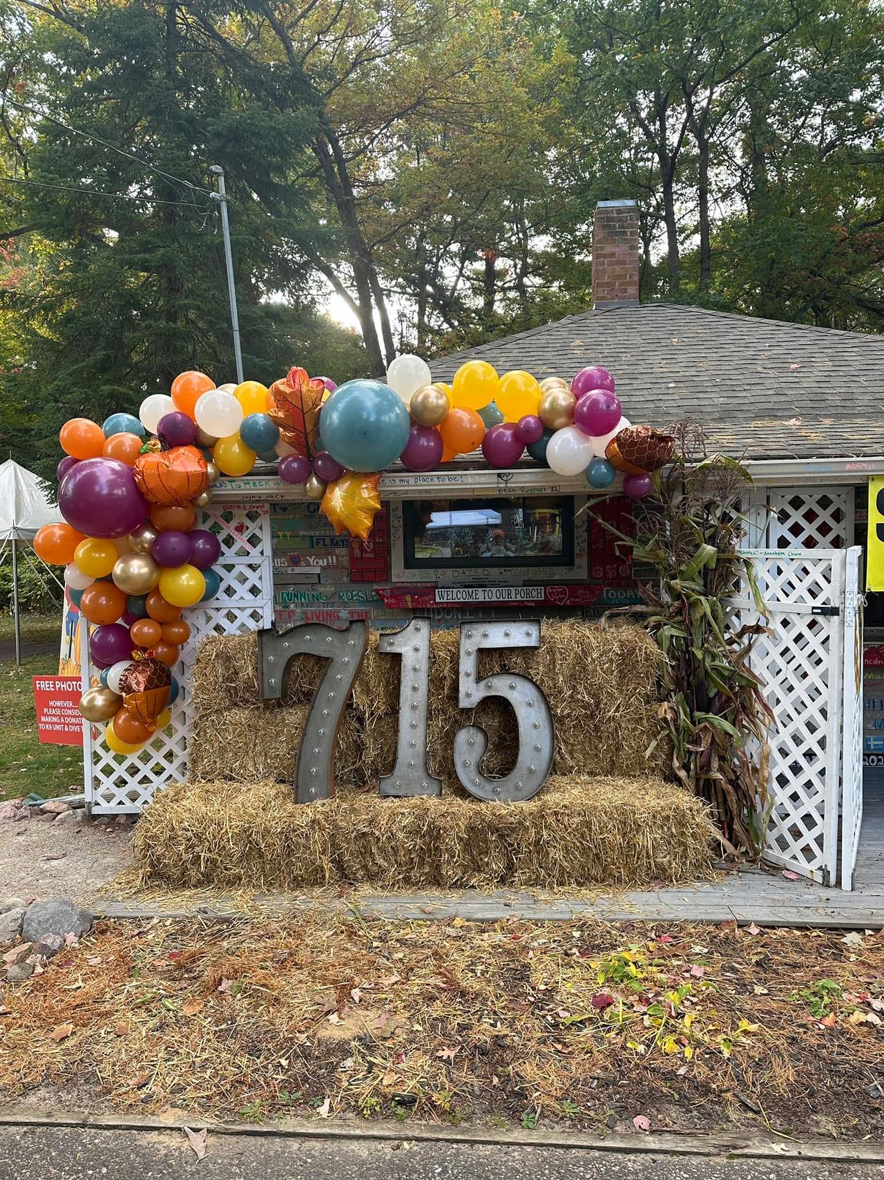 Marquee "715" letters surrounded by pumpkins and hay bales