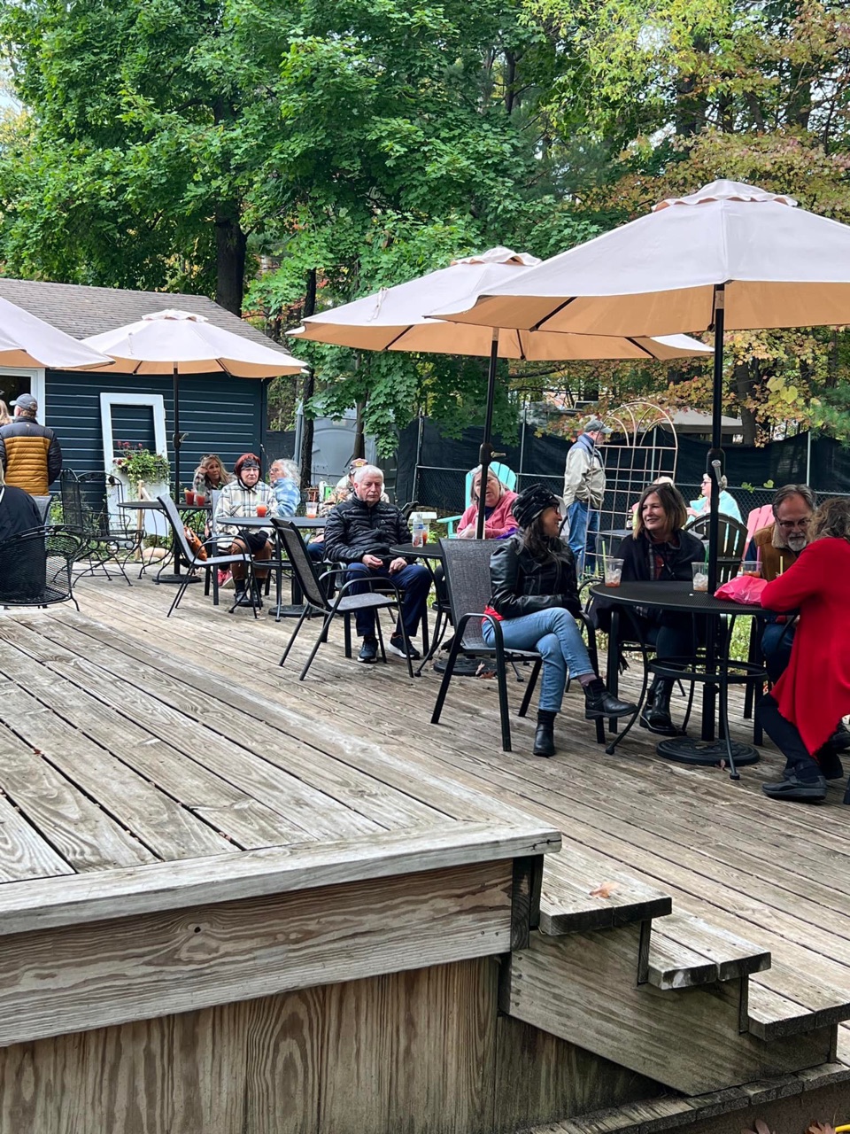 Festival-goers relaxing with food and drinks on a sunny patio